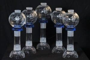 Cinq trophées en cristal représentant des globes pour le biathlon avec le logo de l'IBU.
